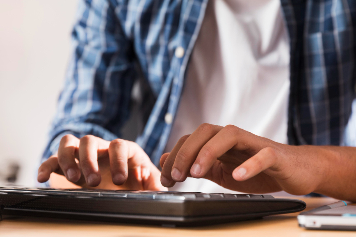 Homem em ambiente de escritório sentado usando computador representando: Reforma Tributária e a neutralidade fiscal: o que significa?