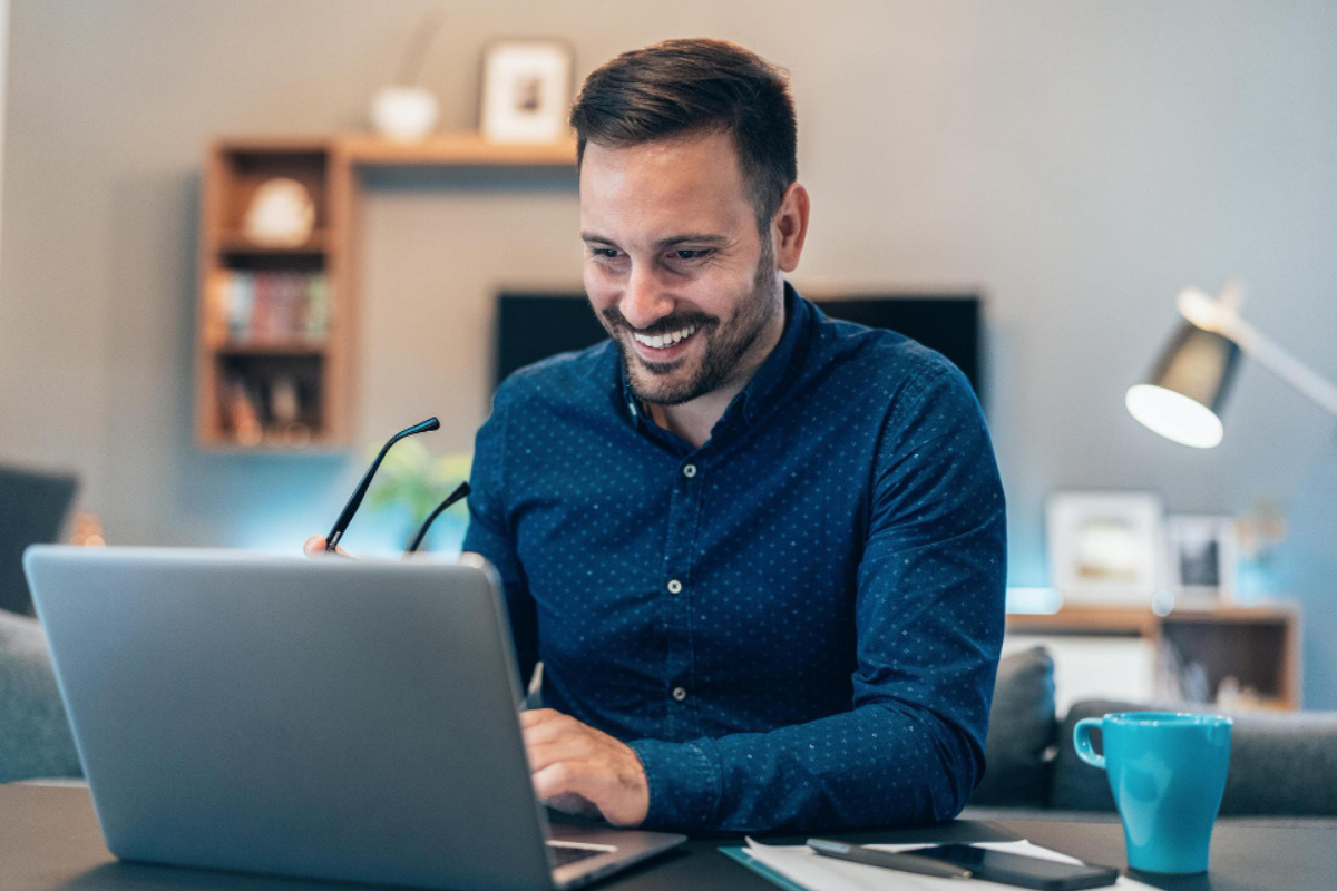 Homem sentado trabalhando em um notebook em ambiente home office representando: A importância das obrigações acessórias e não cumulatividade para o crédito tributário.