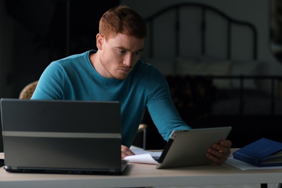 Homem sentado trabalhando em um notebook sobre uma mesa em ambiente home office representando: Como um erro no XML pode impactar no faturamento?