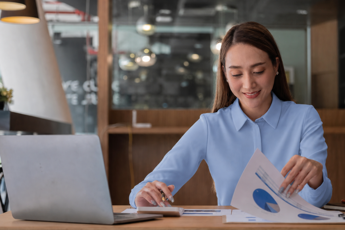 Mulher trabalhando em um notebook sobre uma mesa em ambiente de escritório representando: Automação fiscal: o caminho para reduzir erros na Reforma.