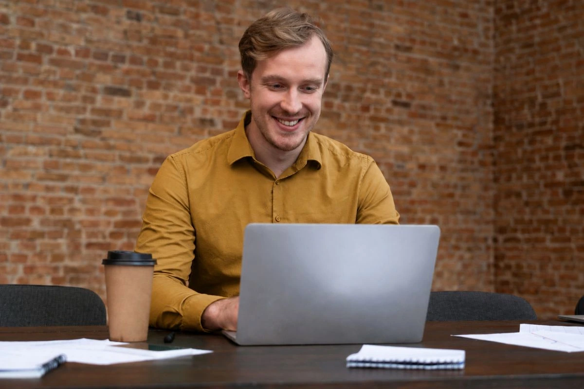 Homem em ambiente de escritório sentado usando notebook para saber como fazer uma auditoria fiscal preventiva.