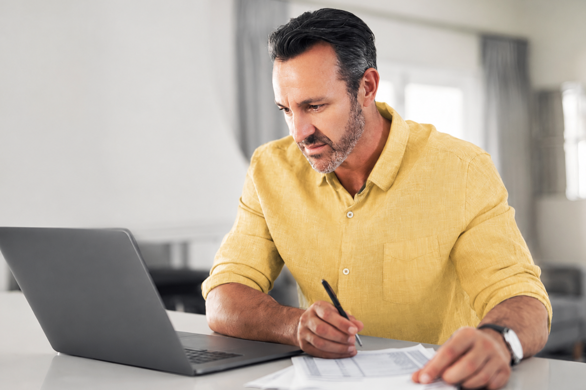 Homem em ambiente de escritório trabalhando em um notebook sobre uma mesa de escritório representando: O que caracteriza erro fiscal na emissão de nota?