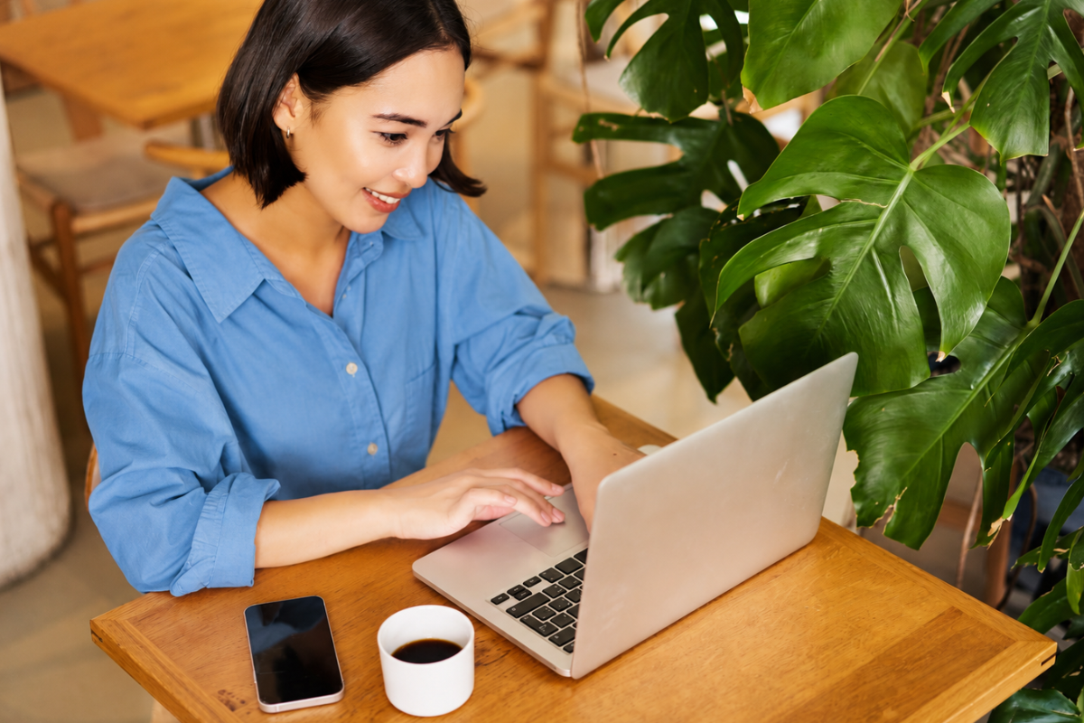 Profissional feminina sentada trabalhando em notebook sobre uma mesa em ambiente de escritório representando: O que fazer ao identificar erro em nota já emitida?